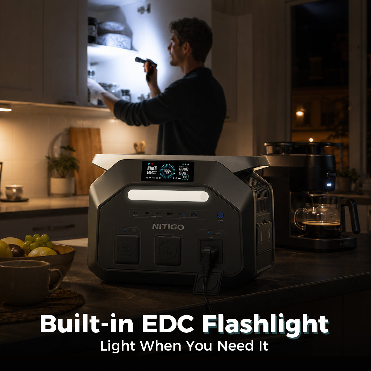 NITIGO P1800 home backup power station with its front light illuminated beside a coffee maker in a dark kitchen